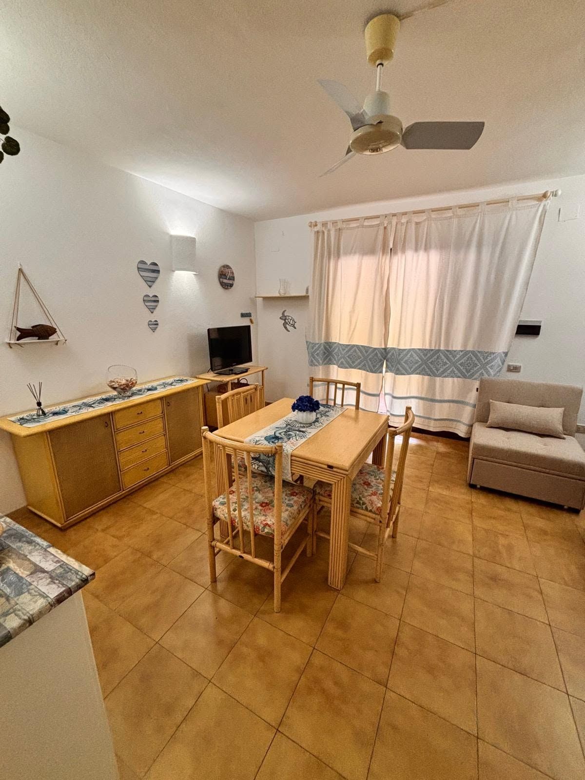 A compact living space with a dining area, kitchenette, and a sofa.