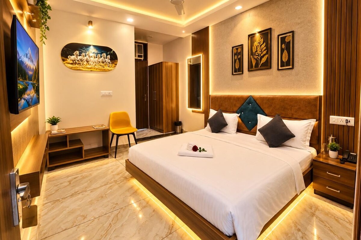 A modern hotel room with a large bed, a desk, and a television.