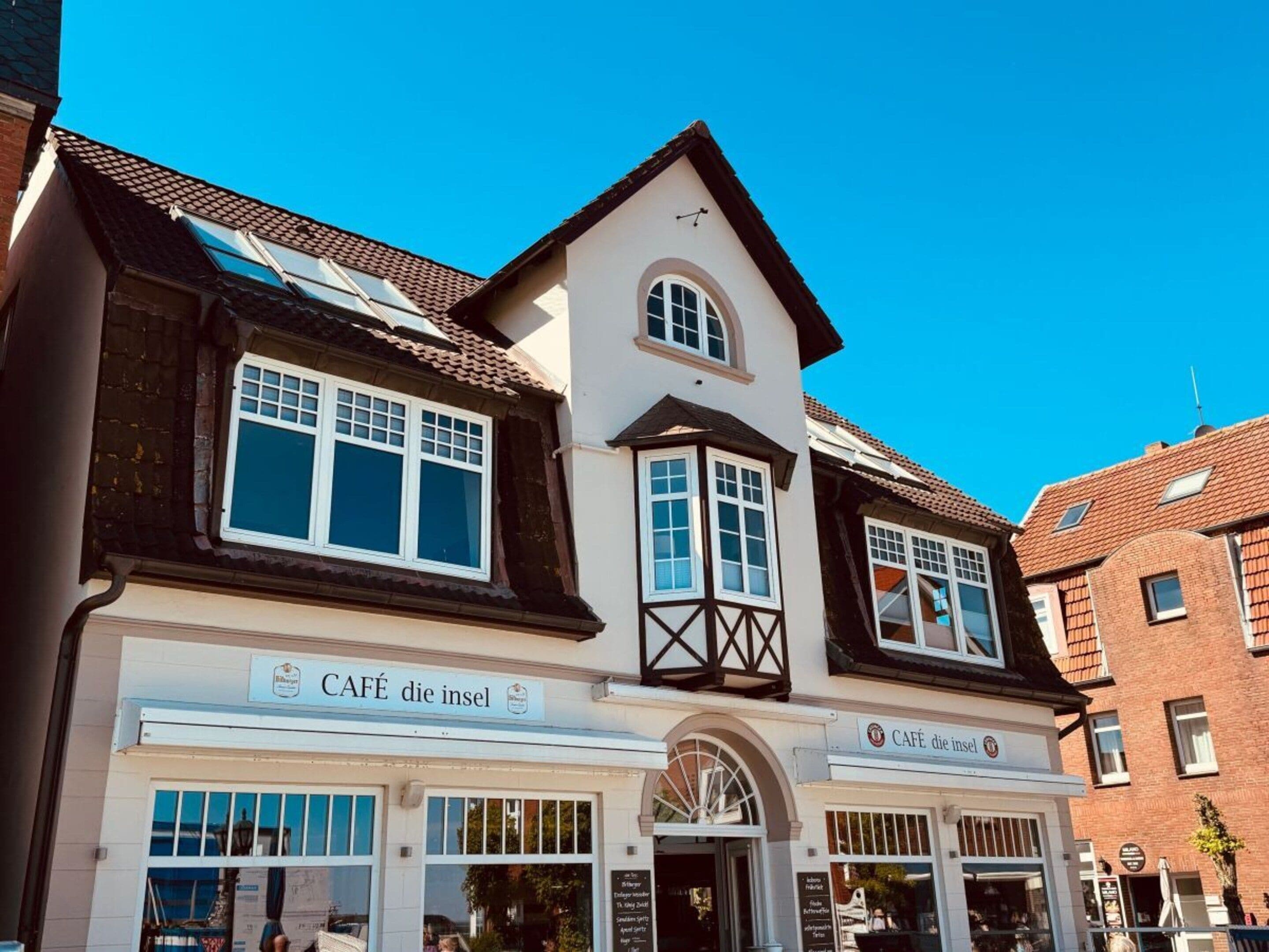 A two-story building with a cafe named 'CAFE die insel' on the ground floor.