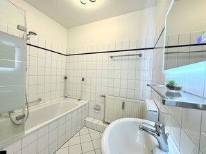Ein modernes Badezimmer mit einer Badewanne, einem Waschbecken und einer Dusche.