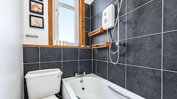 Un baño con bañera, inodoro y ducha.