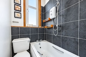 A bathroom with a bathtub, a toilet, and a shower. - Modern 2BR Apartment near Leith Walk (Edinburgh)