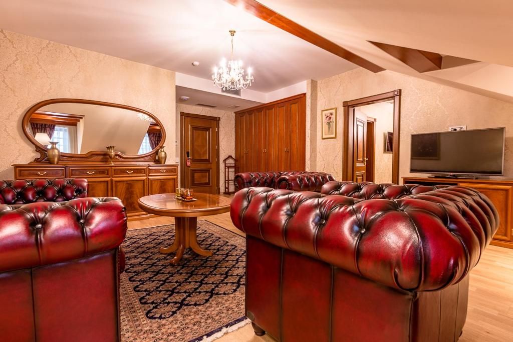 Una sala de estar con sofá, mesa de centro, televisor y un espejo grande.