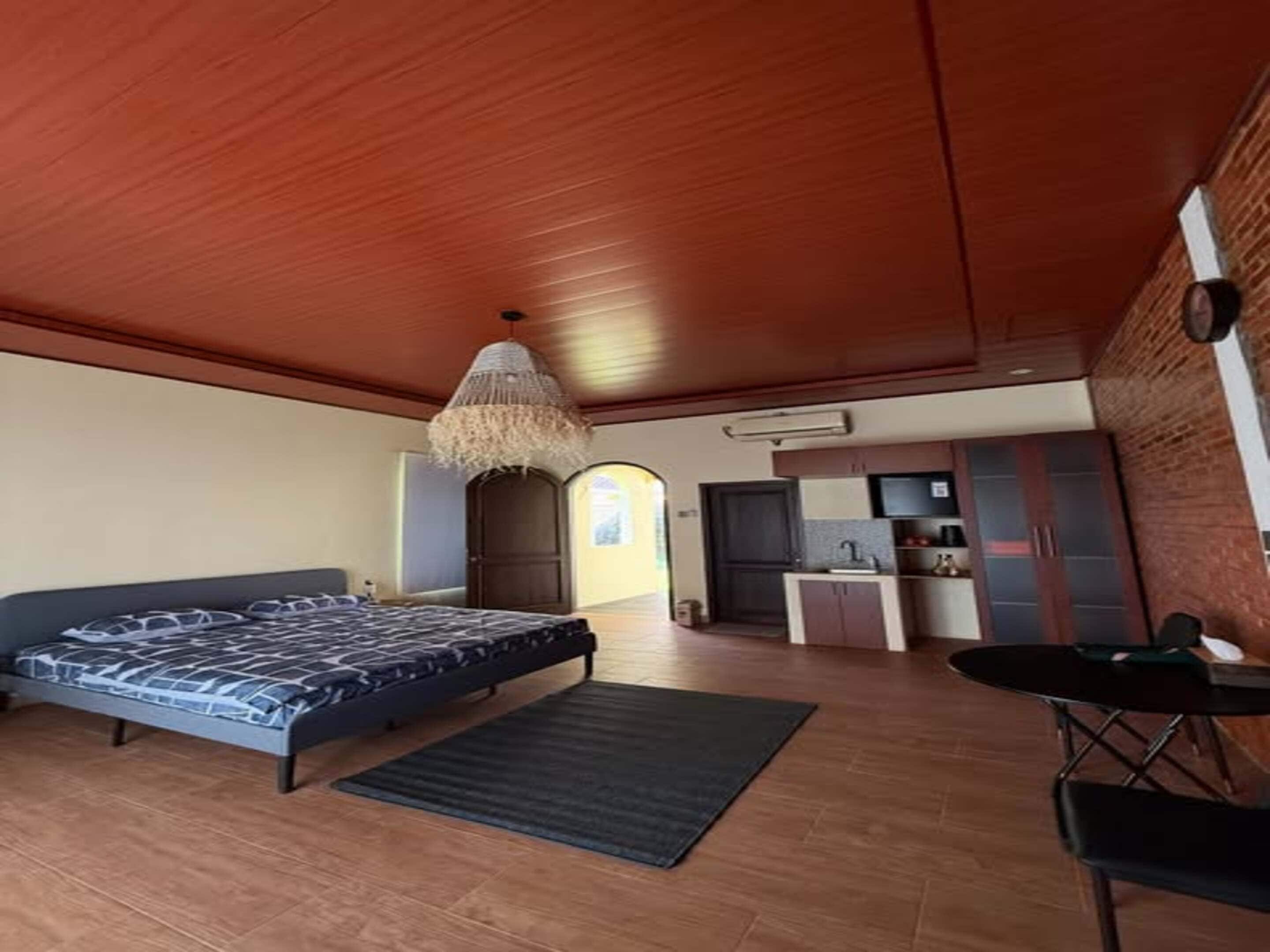 Un dormitorio con cama, escritorio y kitchenette.