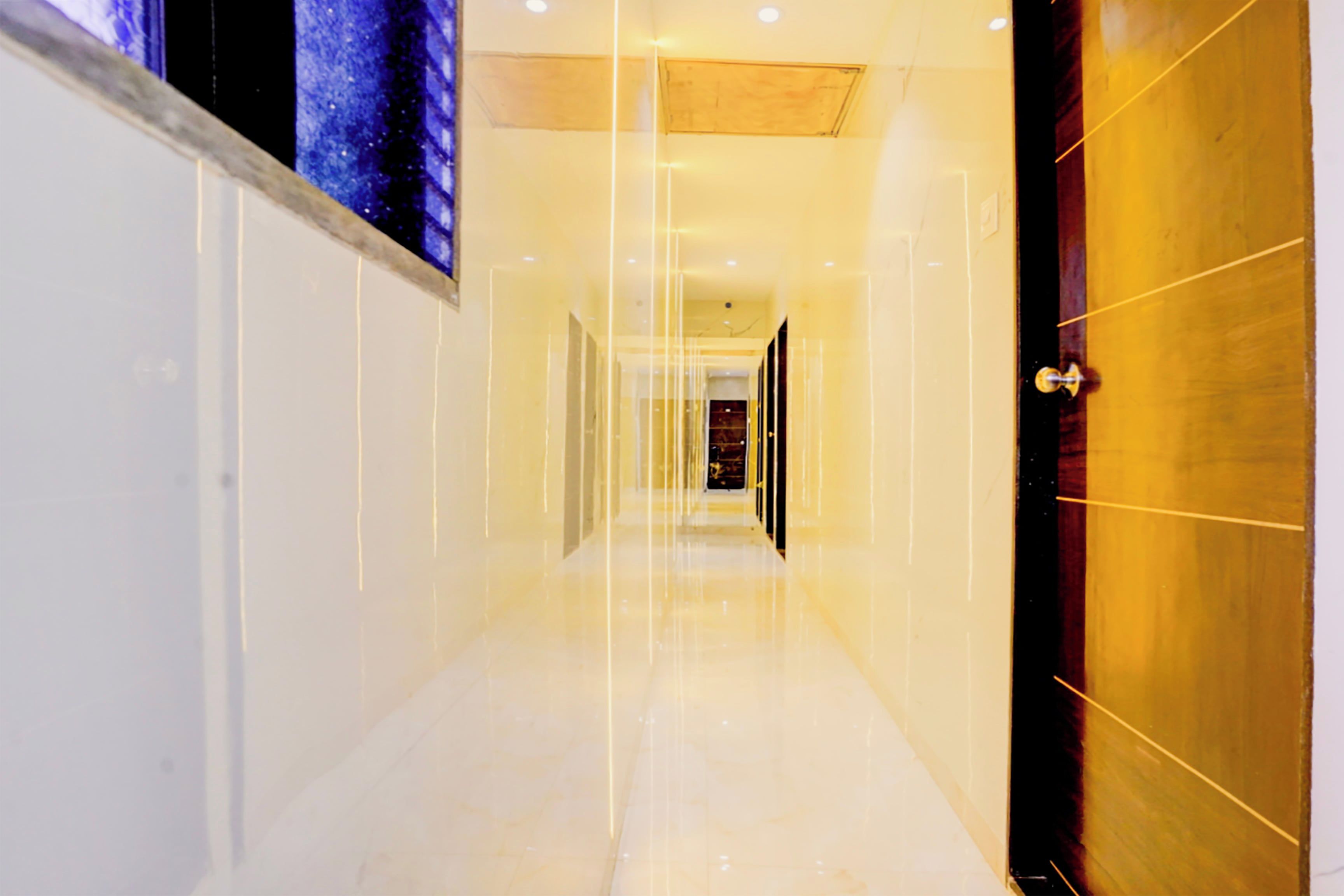 A corridor with a reflective floor and a door on the right.