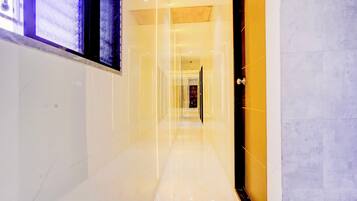 A hallway with a reflective floor and a door on the right.