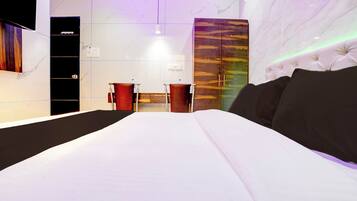 A modern bedroom with a large bed, two bedside tables, and a marble wall.