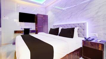 A modern bedroom with a large bed, a television, and a wardrobe.