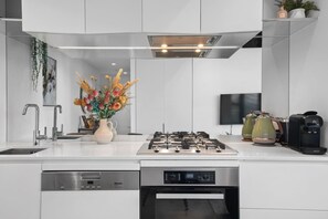 A modern kitchen with a built-in dishwasher, stove, and oven. - Stunning Southbank 2 Bedroom (Southbank)