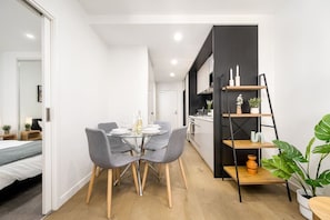 A modern interior with a dining area, a kitchen, and a living space. - Super Central 2 Bedroom (Melbourne)