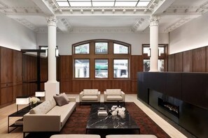 A spacious living room with a fireplace, large windows, and a high ceiling with decorative moldings. - New York Style City 3 Bedroom (Melbourne)