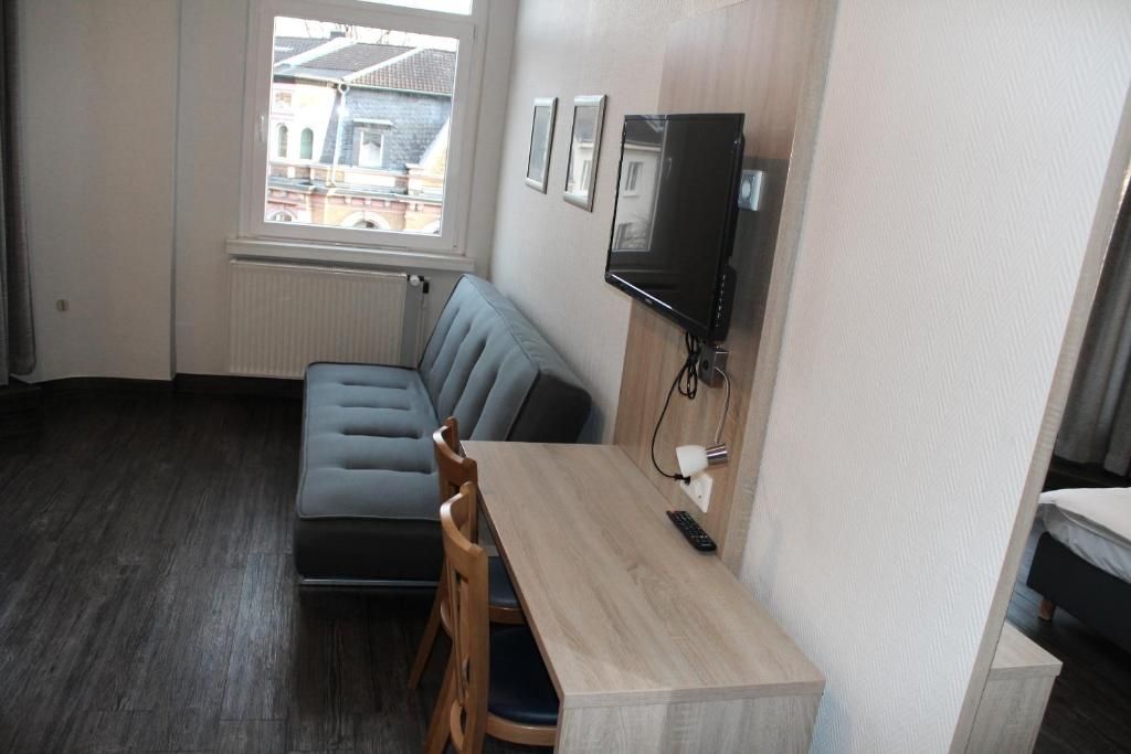 A compact living space with a sofa, a dining table, and a television.