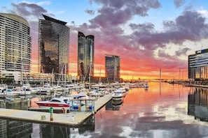 A marina with multiple boats docked, surrounded by modern high-rise buildings. - Marvel Penthouse with Pool (Docklands)