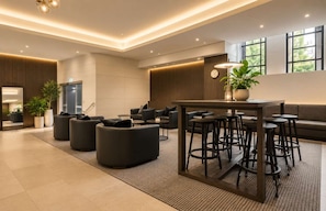 A modern lobby with seating areas, a bar, and large windows. - Zen City Retreat with Parking (Melbourne)