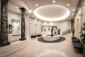 A spacious lobby with a central fountain, marble columns, and a staircase. - Retro City 3 Bedroom Retreat (Melbourne)