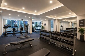 Ein modernes Fitnessstudio mit Laufbändern, Kraftgeräten und Kurzhanteln.