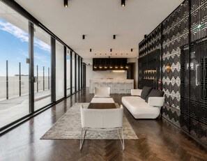 A modern interior with a large window, a kitchen area, and a seating arrangement. - Modern City 2 Bedroom (Melbourne)