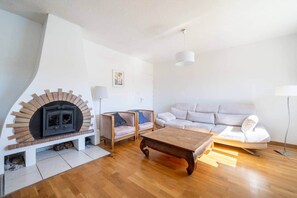 A living room with a fireplace, a sofa, a coffee table, and a lamp. - Villa Lavande: 5-bedroom house in Dieulefit (Dieulefit)