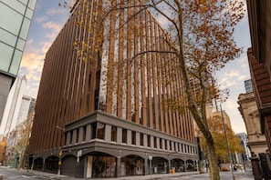 A modern building with a prominent vertical design and a series of windows. - Chinatown 1 Bedroom Apartment (Melbourne)