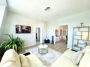 Ein modernes Wohnzimmer mit einer Couch, einem Couchtisch und einem Bild an der Wand.