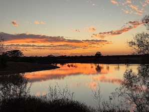 A calm lake reflecting the sky during sunset.