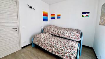 Ein Zimmer mit einem Bett, einem Kleiderschrank und drei an der Wand befestigten Bildern.