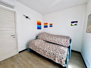 A room with a bed, a wardrobe, and three wall-mounted paintings. - Casa Virginia - Rosmarino: A country home surrounded by nature with a private garden (Armoea)