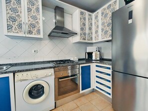 A kitchen with a washing machine, oven, microwave, and a stainless steel refrigerator. - Apartment 'Quinta Da Gomeira 68' with shared pool, Wi-Fi and air conditioning (Tavira)