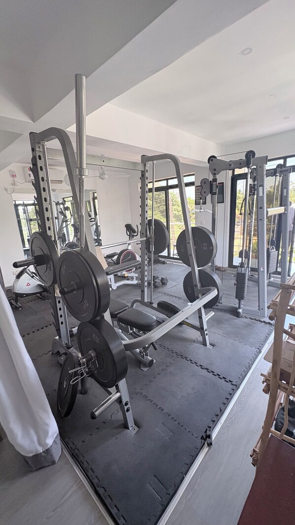 A gym with various exercise equipment, including weight machines and free weights. - Family Luxury suite accommodates 4 guests (Malindi)