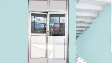 Una esquina de un edificio con una puerta blanca y una escalera.