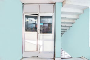 Una esquina de un edificio con una puerta blanca y una escalera.