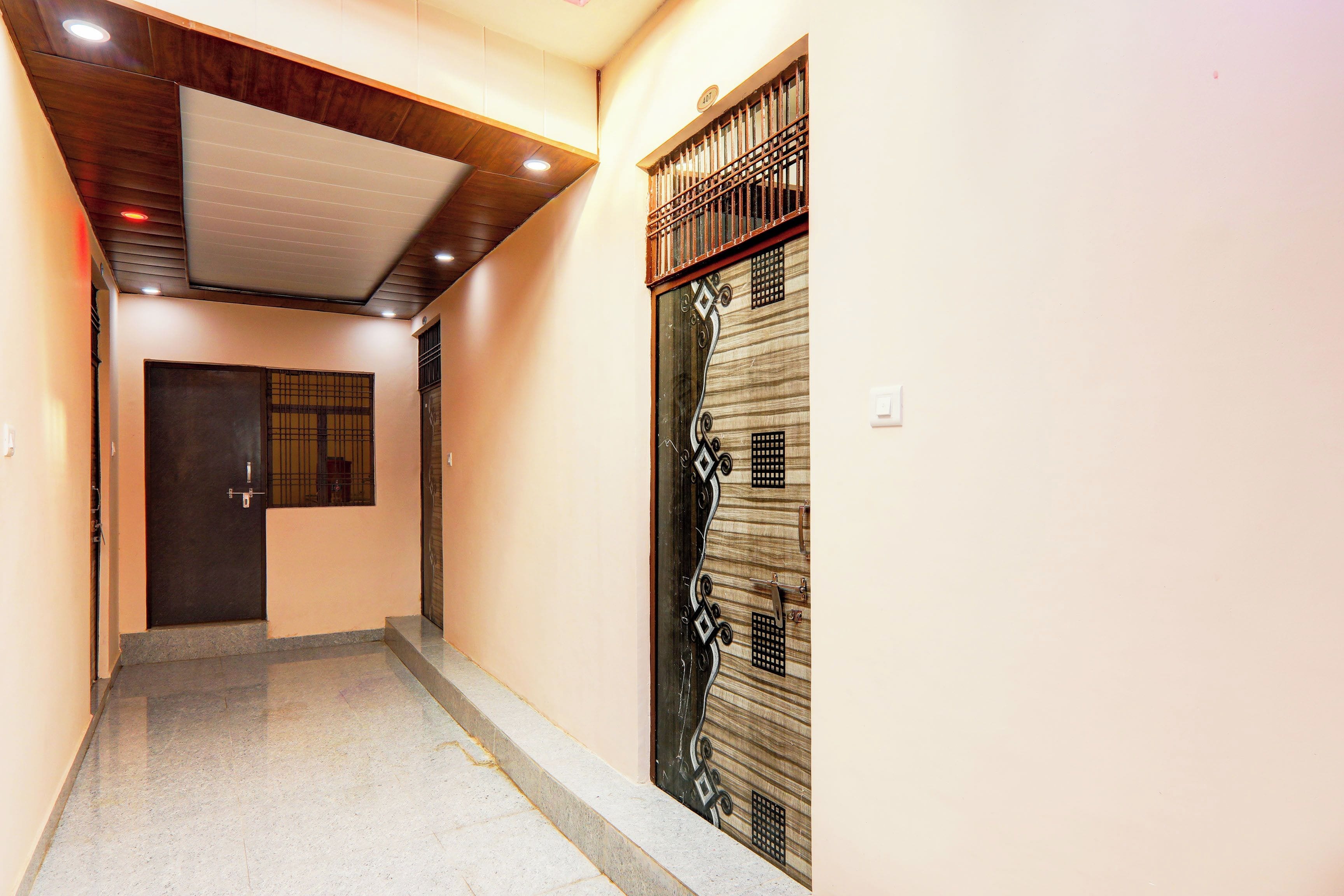 A hallway with a wooden ceiling and a door with decorative metalwork.