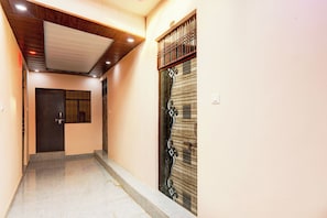Un pasillo con techo de madera y una puerta con detalles de metalería.