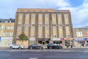 Le Grand Hôtel d’Ilford se distingue par sa façade en briques, ses nombreuses fenêtres et son entrée bien visible.