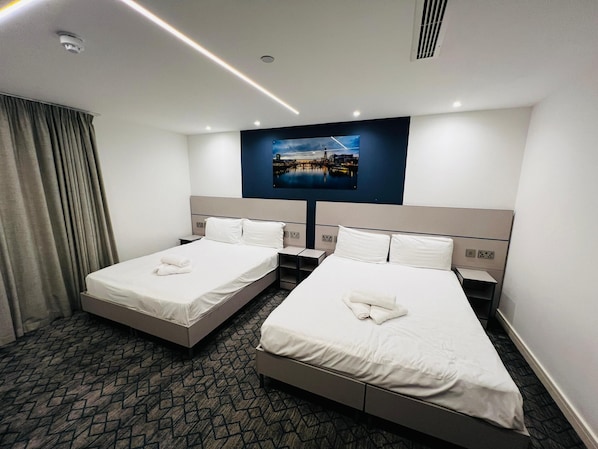 Une chambre d’hôtel avec deux lits, une grande fenêtre et une vue sur la ville.