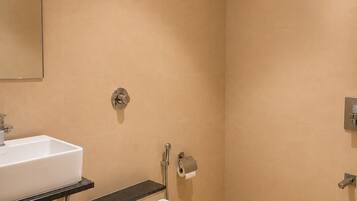 A bathroom with a white sink, a toilet, a shower, and a towel rack.