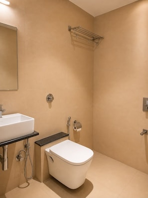 Un baño con un lavamanos blanco, inodoro, ducha y toallero.