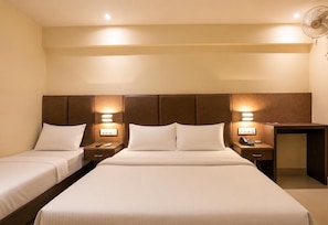 Una habitación de hotel con dos camas individuales, un escritorio y una silla.