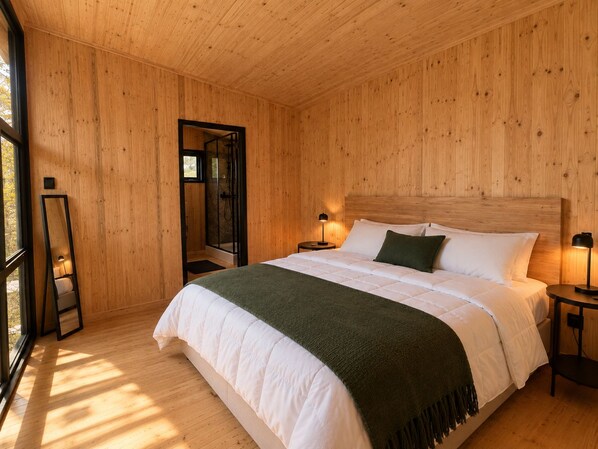 A wooden-paneled bedroom with a bed, bedside lamps, and a large mirror.