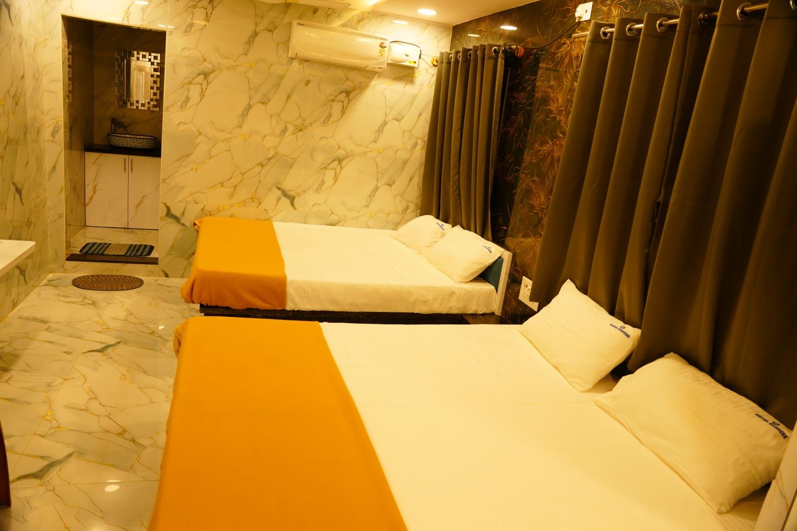 Habitación de hotel con dos camas, baño y zona de ducha.