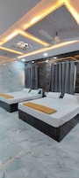 Habitación de hotel con dos camas, un ventilador de techo y suelo de mármol.