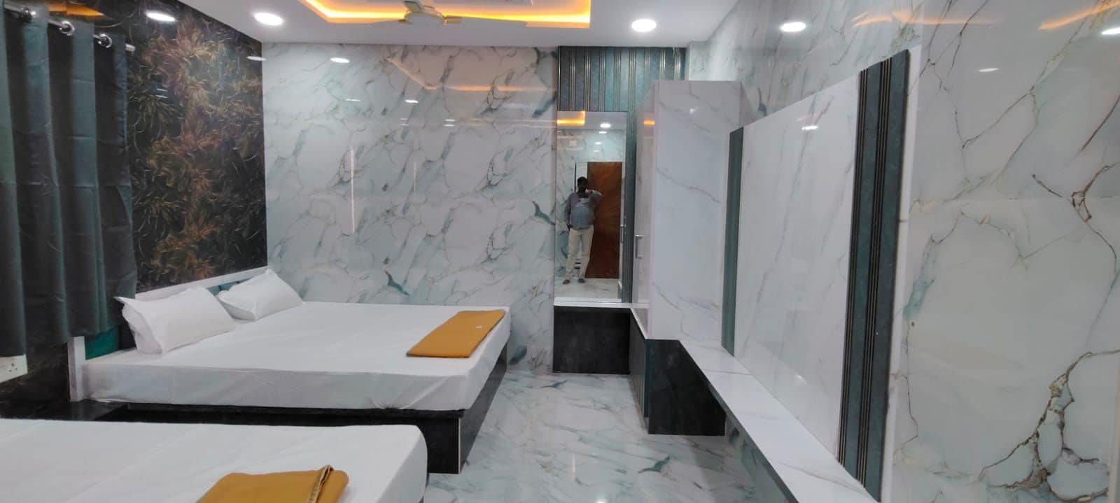 A hotel room with two beds, a bathroom, and a view of the city.