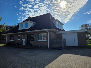 Ein zweistöckiges Haus mit Garage, Ziegelaußenwand und befestigter Auffahrt.