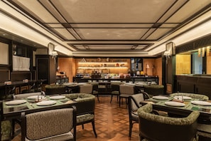A restaurant with a bar area, multiple dining tables, and chairs. - Blossom Manoir Jiefangbei Chongqing (Chongqing)