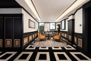 A hallway with a checkered floor pattern, a sofa, and a table with chairs. - Blossom Manoir Jiefangbei Chongqing (Chongqing)