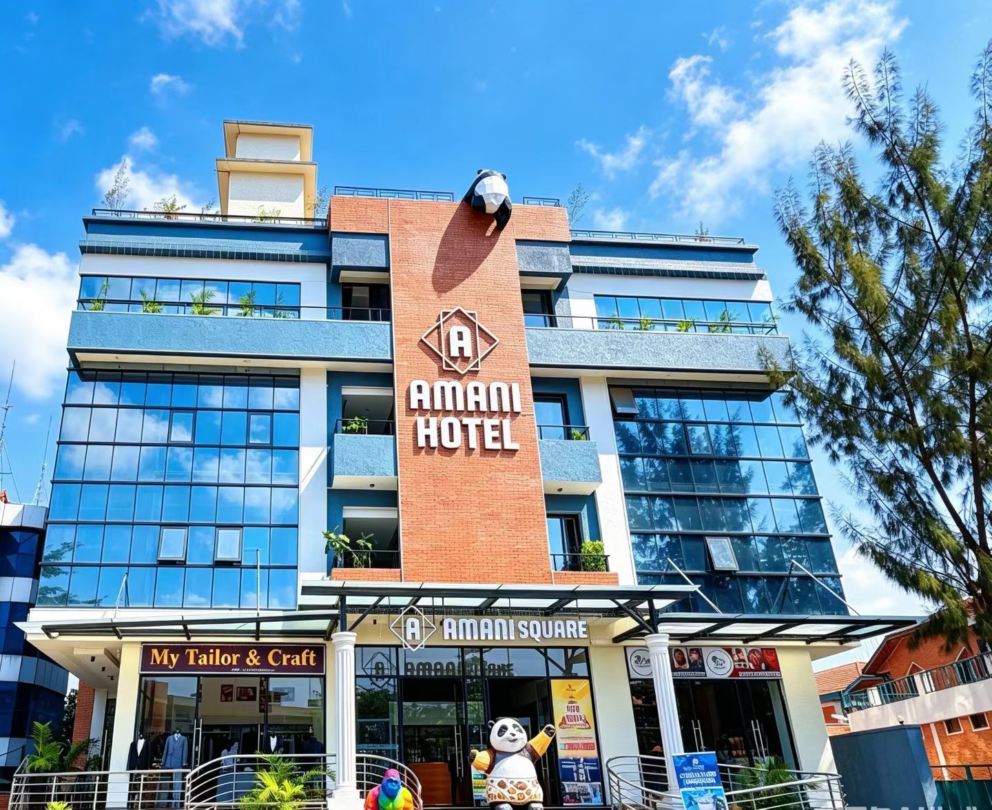 Un hotel con un letrero llamativo, una tienda con un taller artesanal y una estatua de panda.