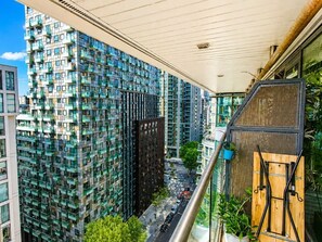 Un immeuble de grande hauteur doté d’une architecture moderne, avec des balcons et une vue sur la rue en contrebas.