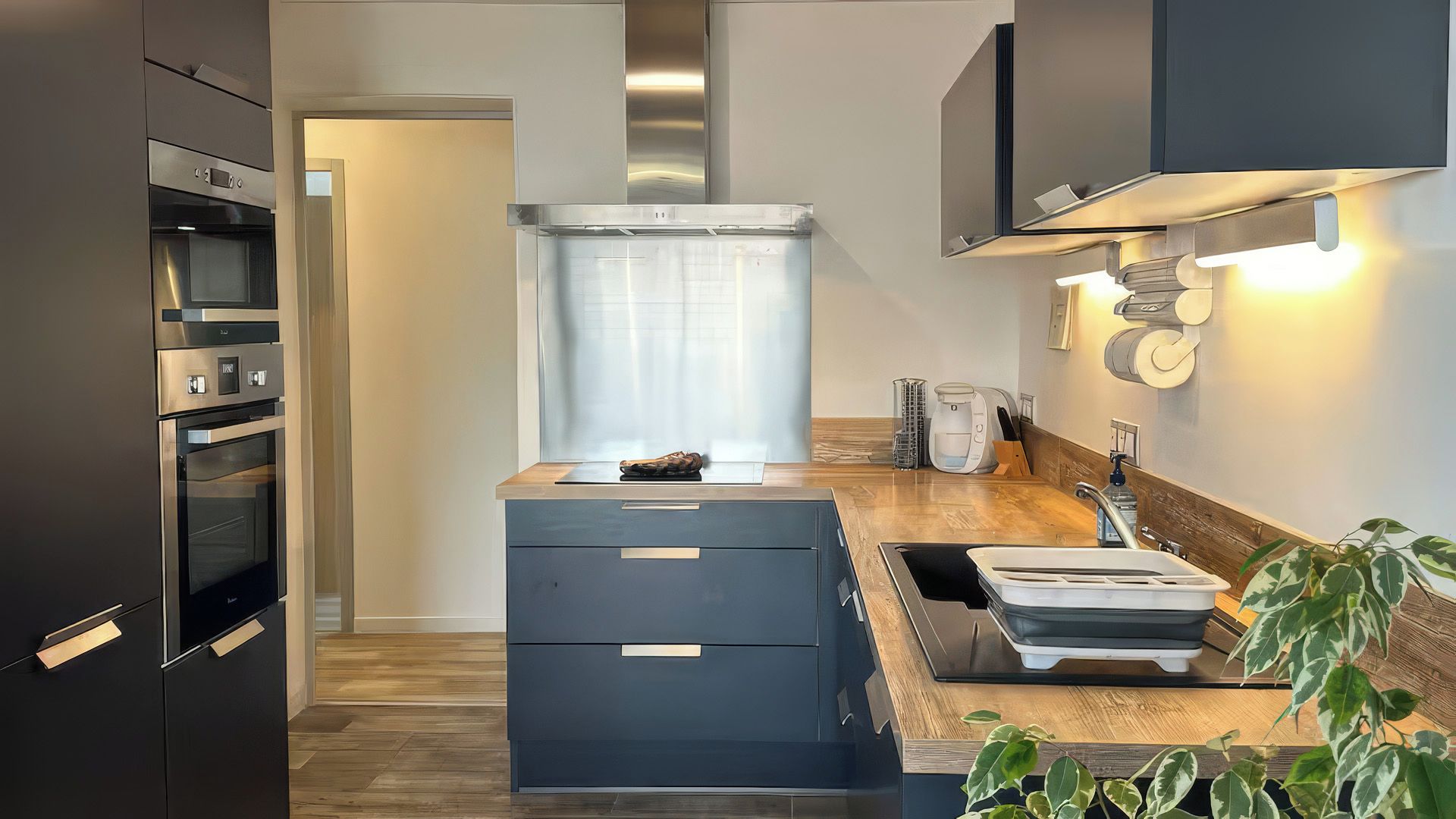 Una cocina moderna con electrodomésticos integrados, una isla central y vistas al salón contiguo.
