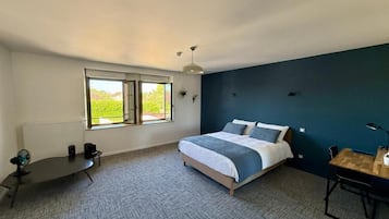 A bedroom with a bed, a desk, a chair, a radiator, and a window.