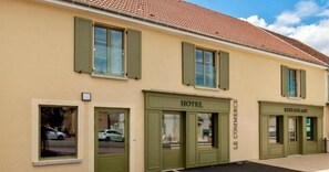 A building with a green facade, a sign for a hotel, and a restaurant. - Le Billot (Bologne)